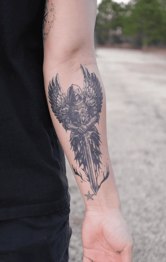 A detailed black-and-gray tattoo of a dagger with wings