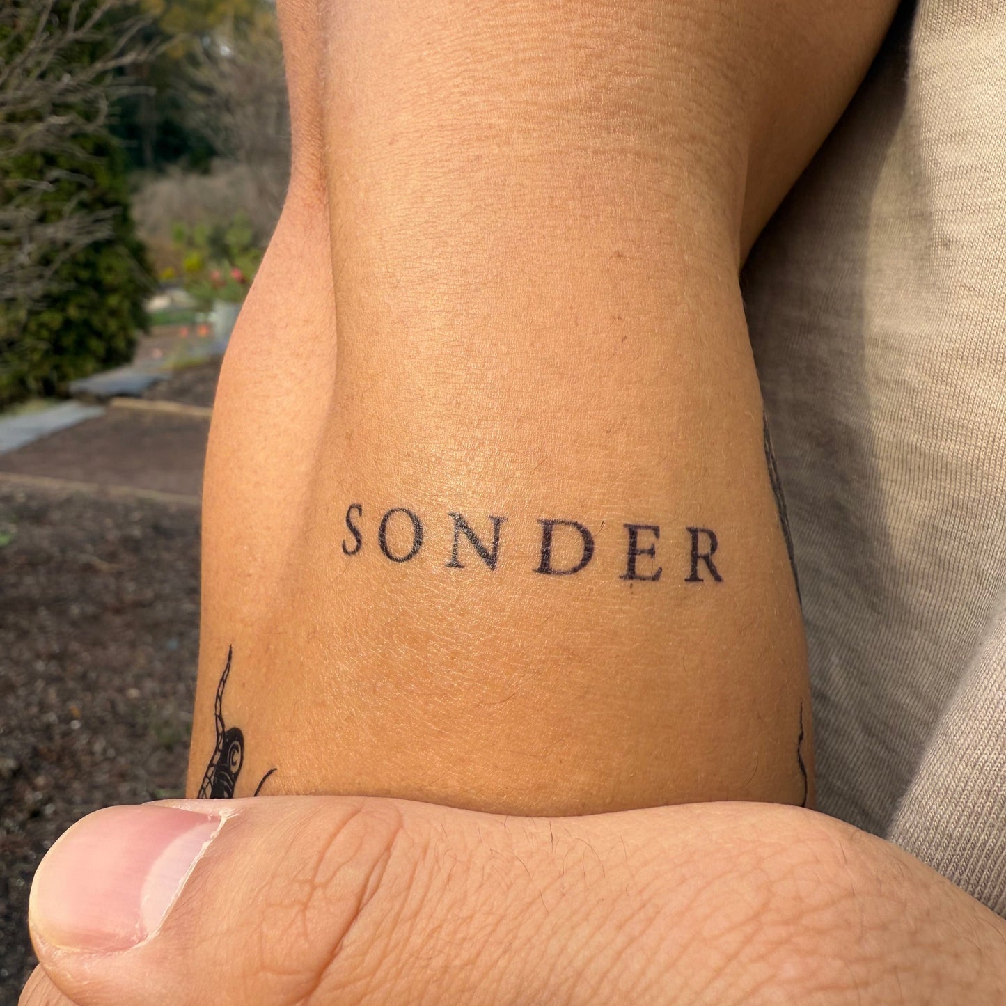 Sonder temporary tattoo on forearm. SteezyInk semi-permanent tattoo, reminder of shared human experience