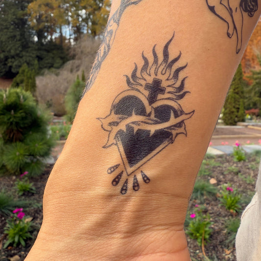 SteezyInk Heart Cross temporary tattoo on wrist. Black heart, cross, and flames tattoo.