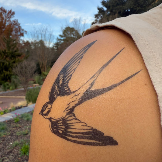 SteezyInk Swallow Temporary Tattoo on arm, black design of flying bird with wings spread