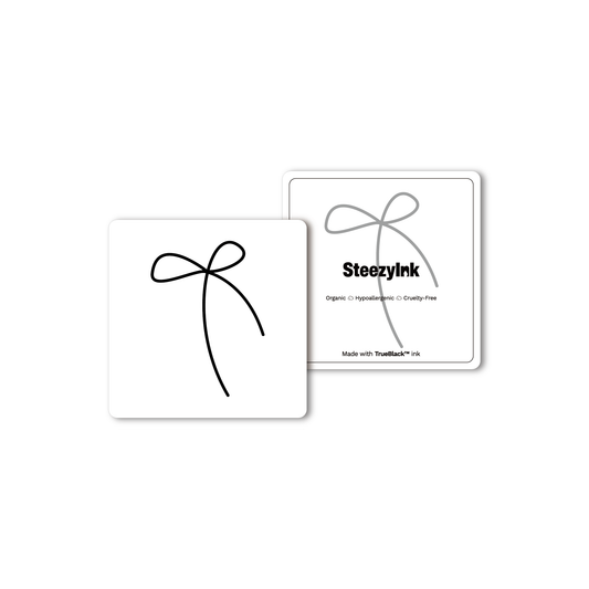 Line Bow temporary tattoo in black, using Pure Black Ink™. Minimalist design, organic and hypoallergenic.