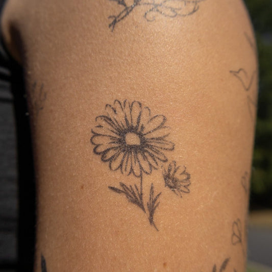 Daisy Delight temporary tattoo, a black floral design on arm, 2 x 2 inch, Pure Black Ink™