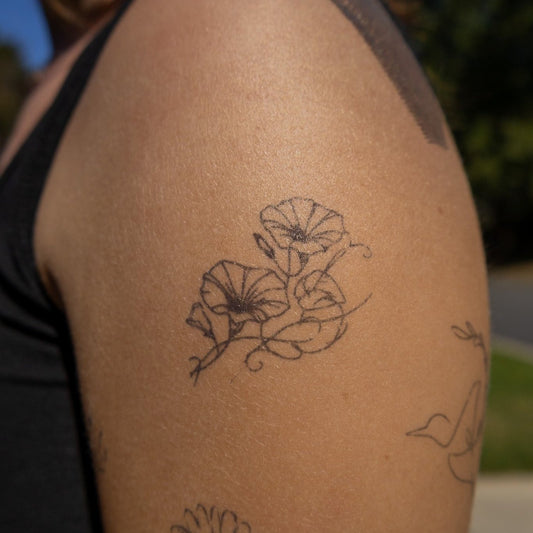 Semi-permanent tattoo of morning glory flowers on arm, botanical design.