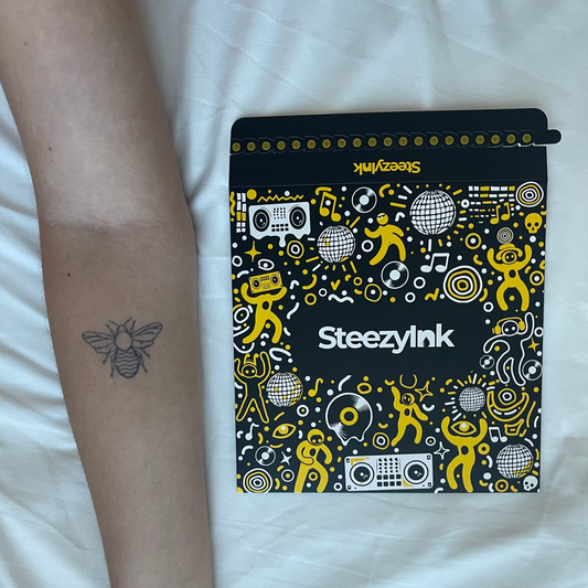 SteezyInk Buzzing Bee temporary tattoo on arm with a SteezyInk package, bee represents community, productivity, and nature.