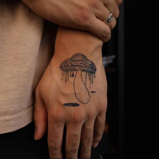 Custom semi-permanent mushroom tattoo with drip effect on hand. SteezyInk product.