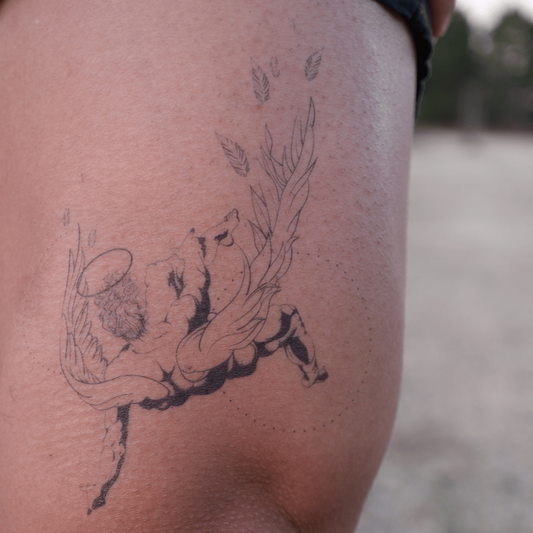 SteezyInk Fallen Angel Temporary Tattoo on thigh, black ink design, expressing themes of loss and beauty