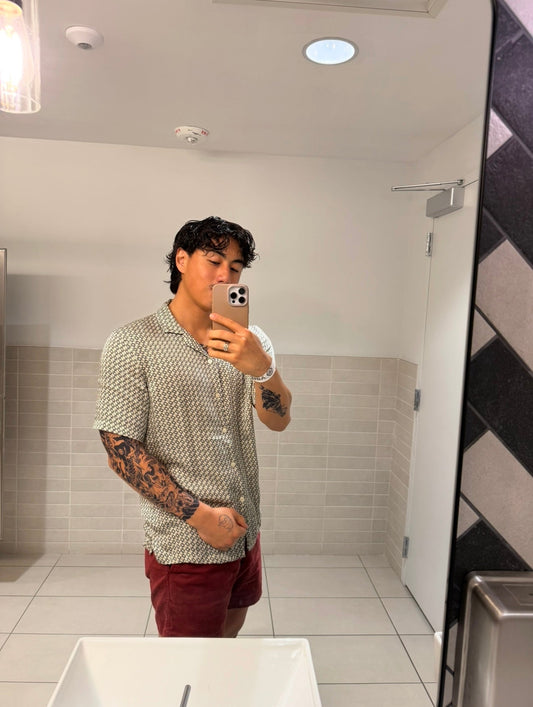 A man takes a picture of his tattoo in front of a mirror