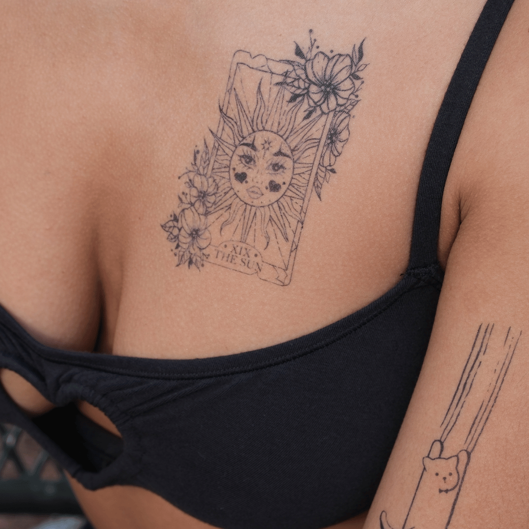 SteezyInk Radiant Sun temporary tattoo on skin, featuring floral details, and 'The Sun' card design